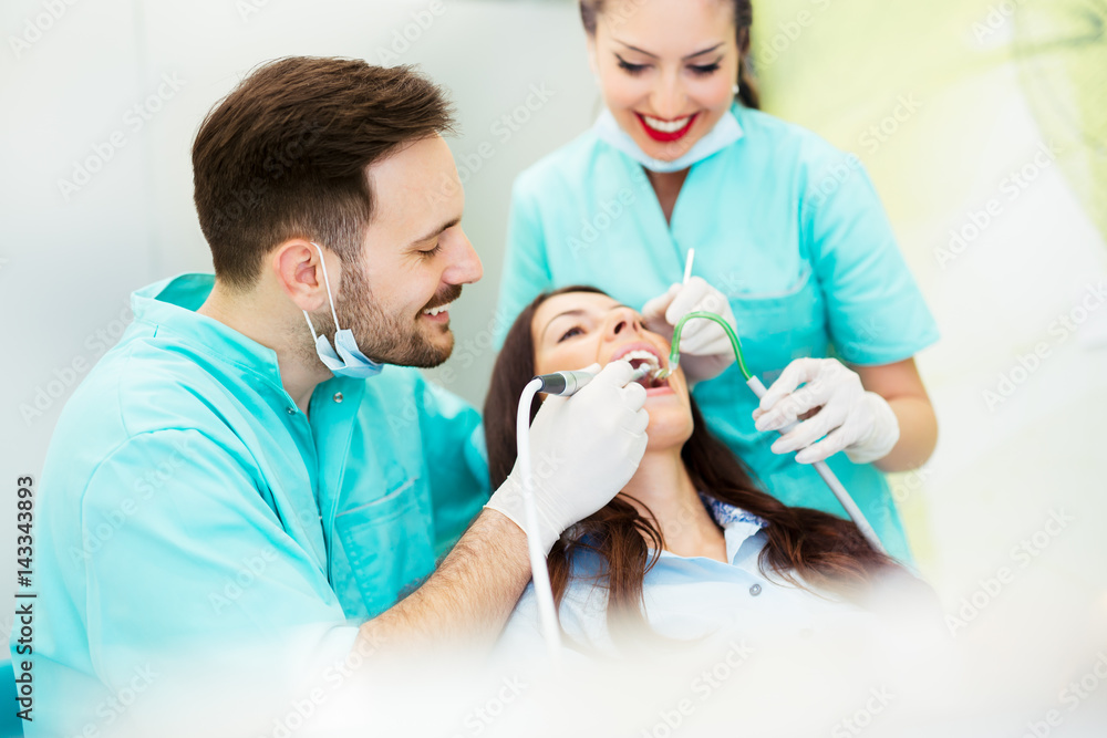 A dentist with assistant working on a patient A dentist with assistant working on a patient