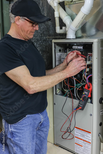 Vászonkép HVAC Technician repairing furnace