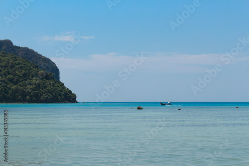 Long Tail boat in Thailand cruising on cyan blue water