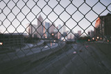 Grunge city skyline through the wire mesh fence
