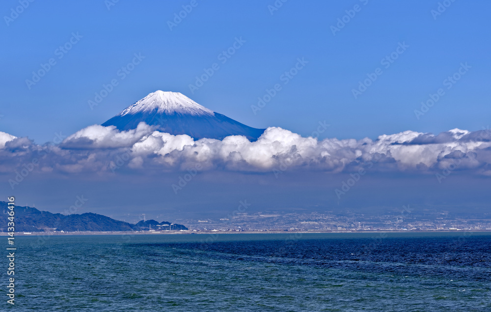 Sea approach to Shimizu, Japan with the sunlit snow capped peak of Mt. Fuji gleaming in the background 