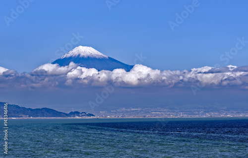 Sea approach to Shimizu  Japan with the sunlit snow capped peak of Mt. Fuji gleaming in the background 