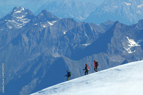 Group of walking Tourists on the glacier with mountains on background