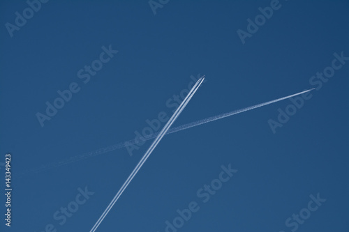 kondensstreifen vom flugzeugen am himmel kreuzen photo