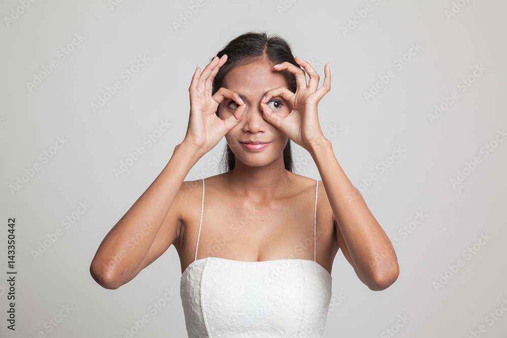 Fototapeta premium Asian woman do funny double OK sign as glasses.