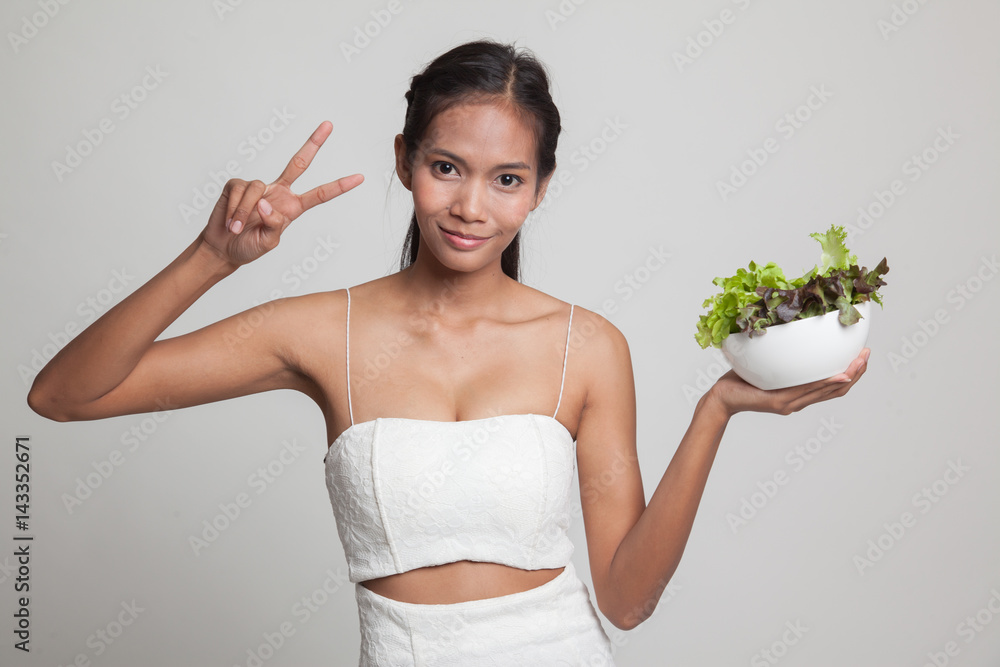 Healthy Asian woman show victory sign with salad. Healthy Asian woman show victory sign with salad.