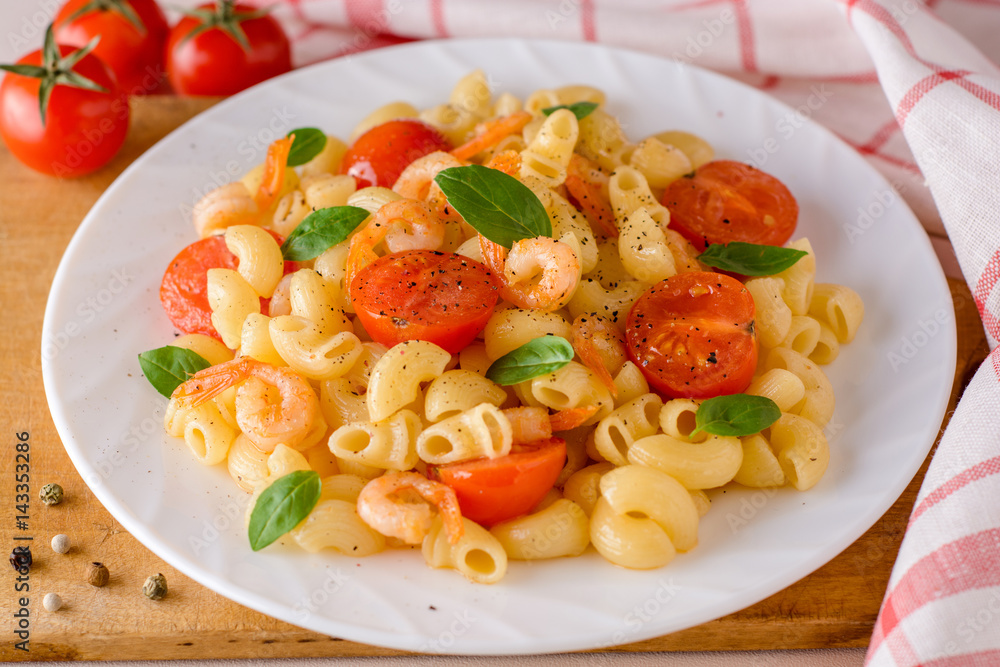 Pasta with shrimps, cherry tomatoes and basil in white plate. Pasta with shrimps, cherry tomatoes and basil in white plate.