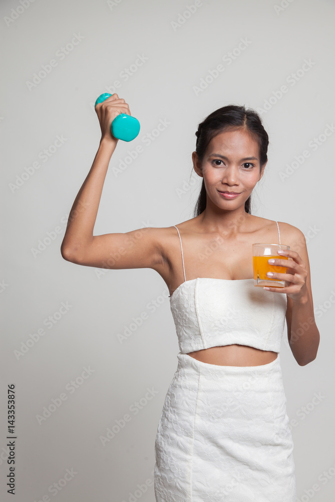 Young Asian woman with dumbbell drink orange juice. Young Asian woman with dumbbell drink orange juice.