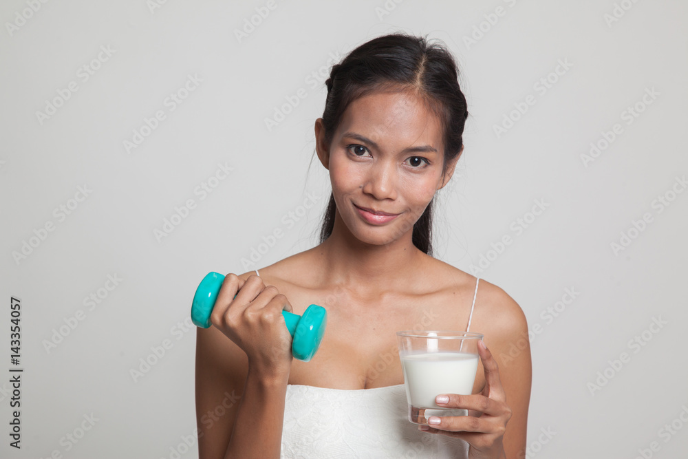 Healthy Asian woman drinking a glass of milk and dumbbell. Healthy Asian woman drinking a glass of milk and dumbbell.