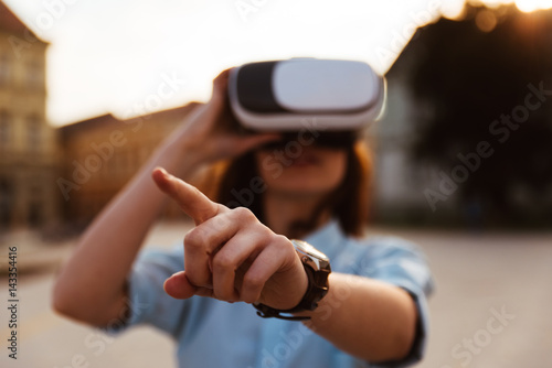 Young woman using a virtual reality headset in the city
