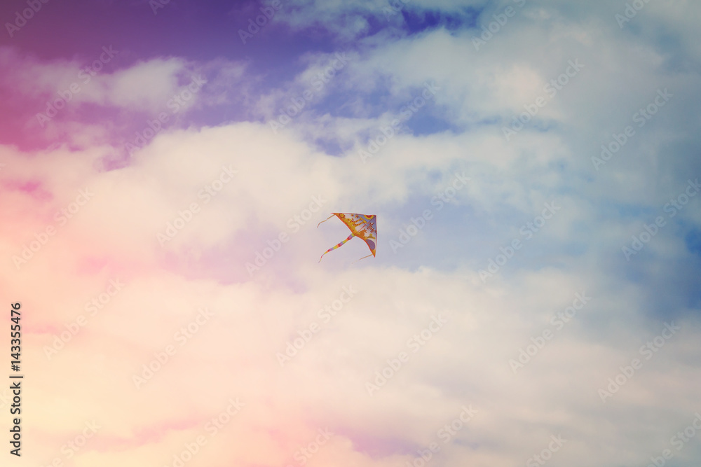 Colorful kite flying high in the blue sky with sunlight Colorful kite flying high in the blue sky with sunlight