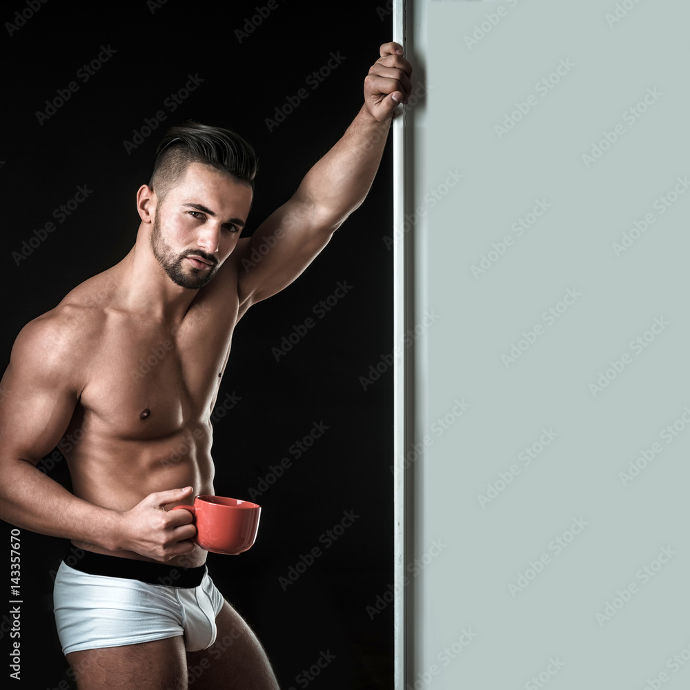 Morning for lonely man. Sexy guy from seductive look. Morning coffee or  tea, tasty and cheerful morning. Sensual man with athletic muscles.  Businessman at home after work or before work Stock Photo