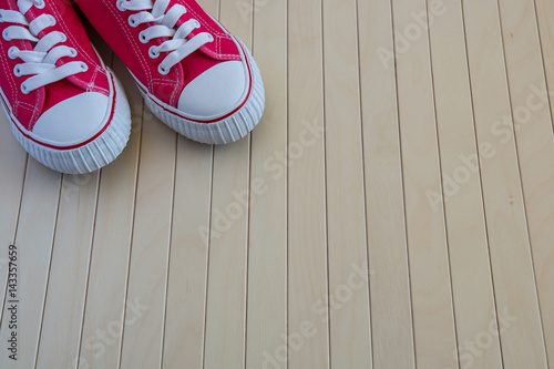 Red new sneakers on the wooden background