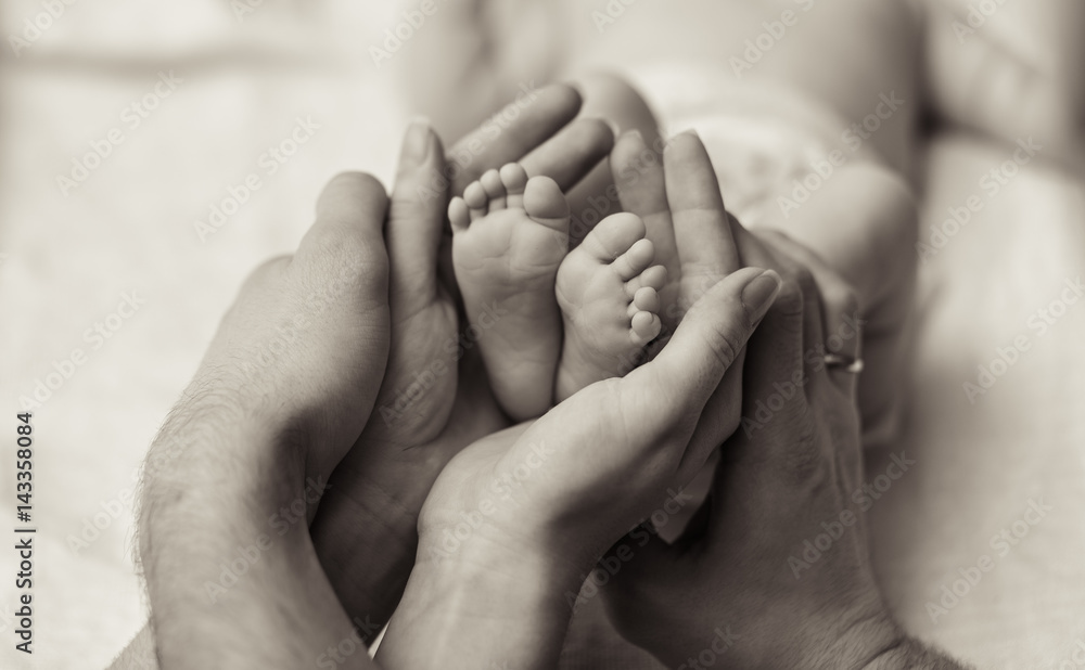 Mother holding tiny foot of newborn baby Mother holding tiny foot of newborn baby