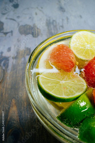 Citrus in water with bubbles in transparent plate Oranges, lemons, greyfrut, Pamela lemonade photo