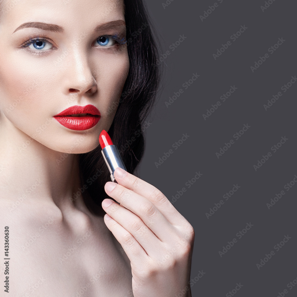 Young brunette woman paints her lips bright red lipstick. Bright evening makeup. Naked girl taking care of her face and lips Young brunette woman paints her lips bright red lipstick. Bright evening makeup. Naked girl taking care of her face and lips