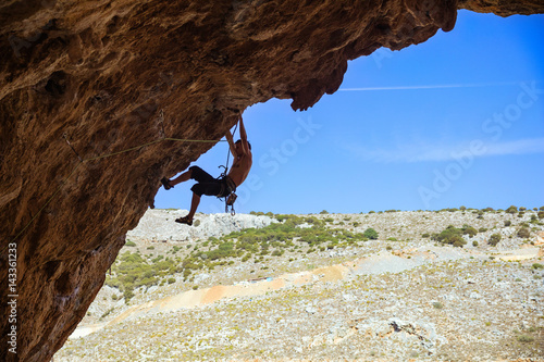 Young man lead climbing in cave