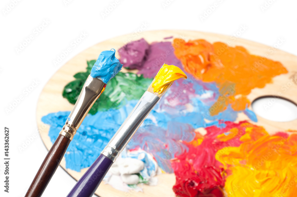 Obraz premium Colored artist's oil paint and brushes on the wooden palette