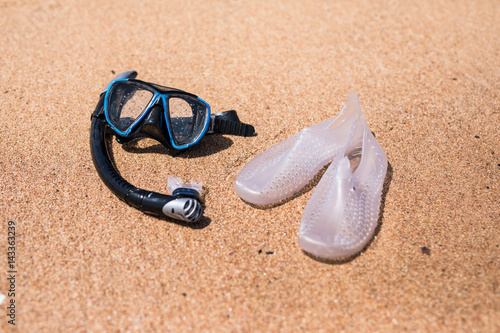 Holidays Background. Diving mask and flip-flops on the ocean beach