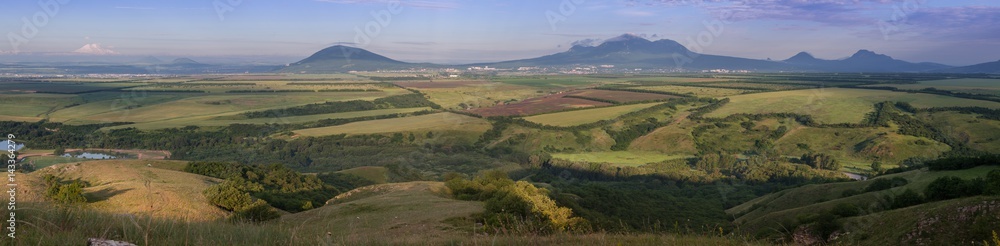  Stavropol Territory. panorama. The city of Pyatigorsk is surrounded by mountains and fields in the summer morning.