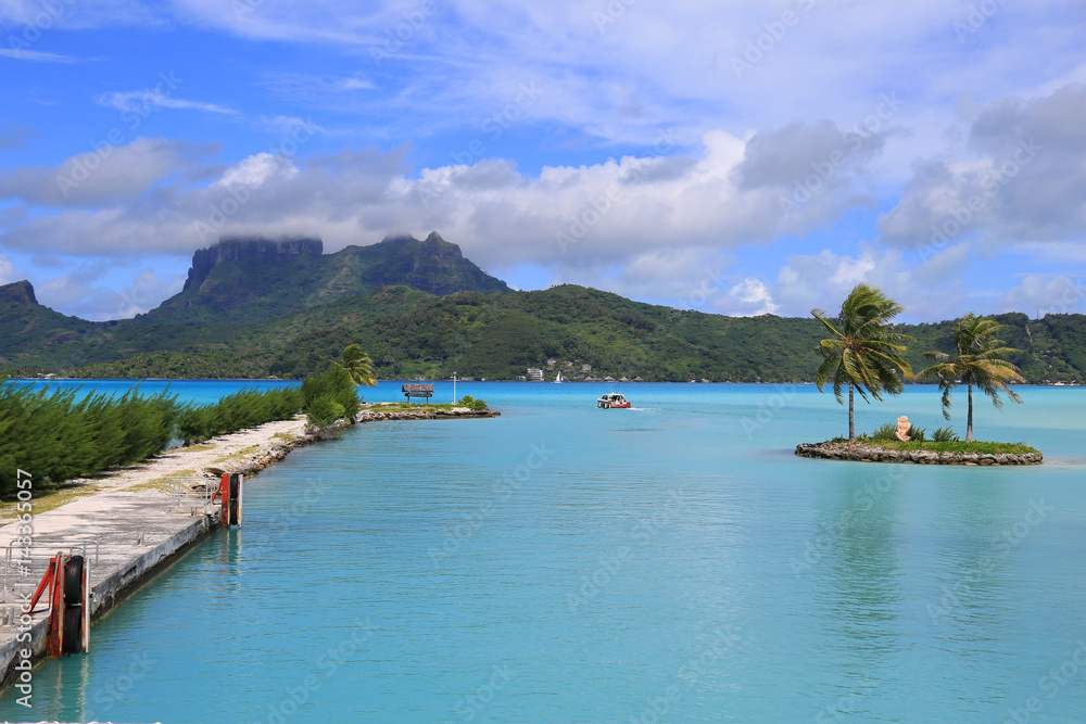 View from Bora Bora airport. Beautiful palms, mountains and blue sea. French Polynesia, South Pacific Ocean.