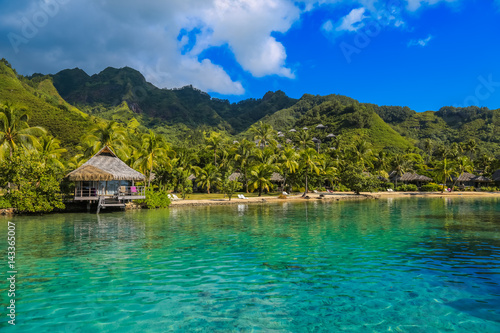 Island of Moorea in the French Polynesia with her exuberant vegetation, turquoise lagoon, bungalow and mountains.