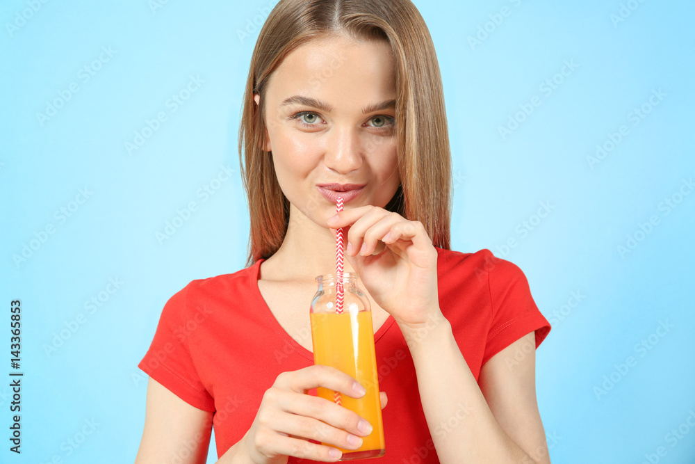 Young beautiful woman with a glass of fresh juice on grey background Young beautiful woman with a glass of fresh juice on grey background