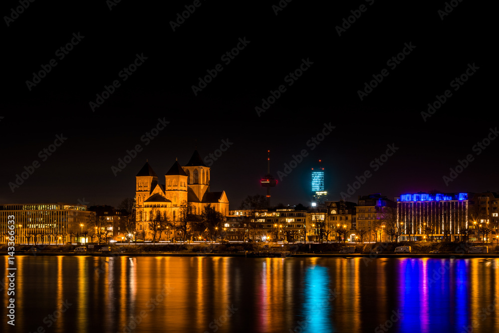 Skyline of Cologne at night with the Basilica of St. Cunibert, the Cologne Tower, the Colonius and the river Rhine