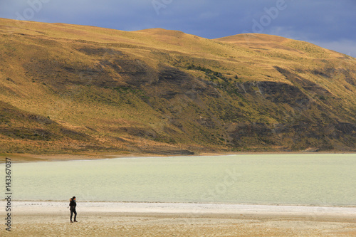 Woman walking close to a salt lake in Torres del Paine, Patagonia, Chile