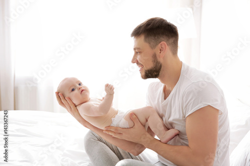 Father sitting with cute ba...