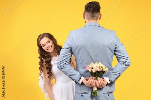 Happy wedding couple on color background