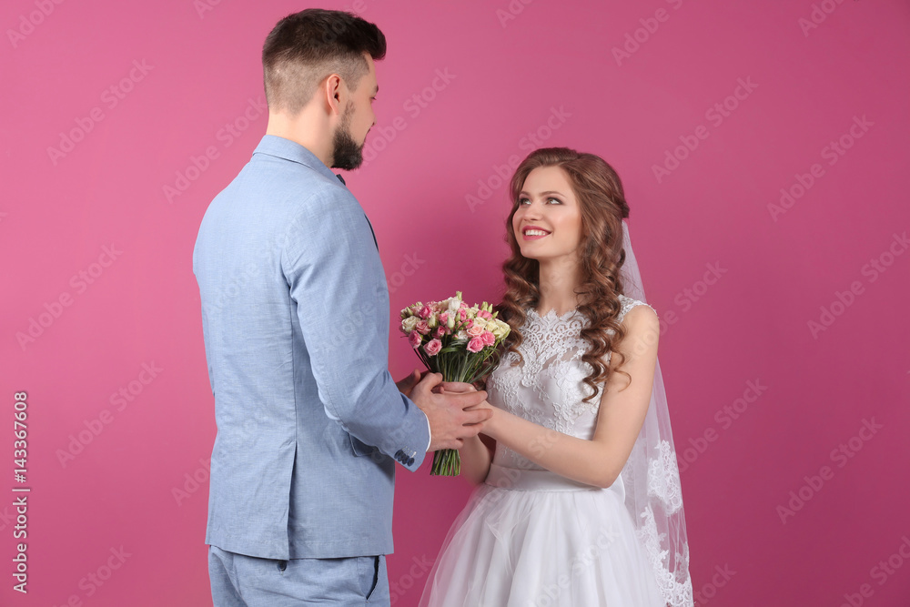 Happy wedding couple on color background Happy wedding couple on color background