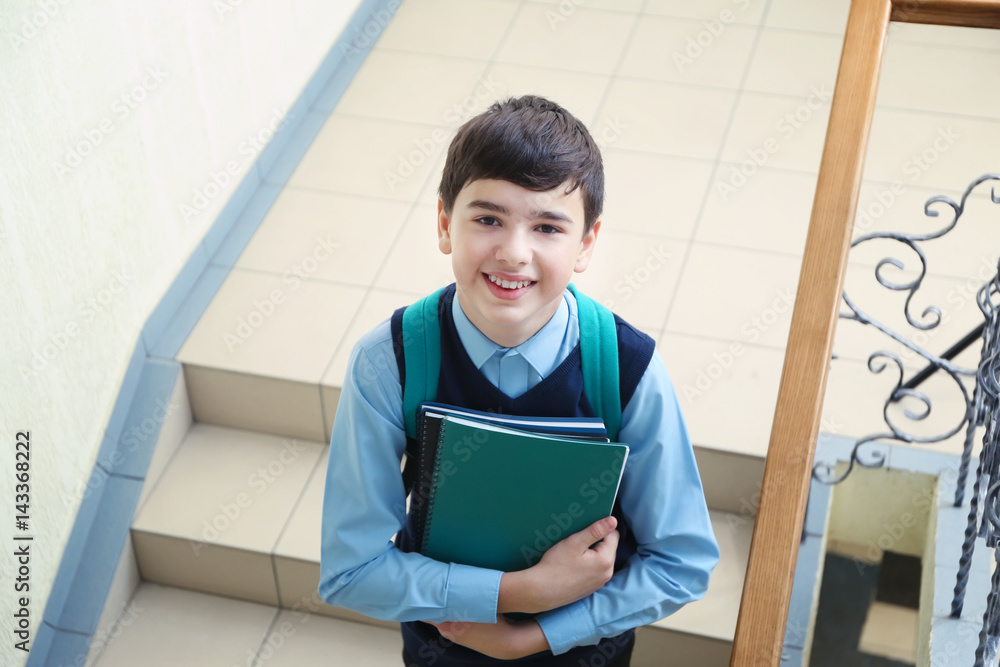 Cute boy in school uniform standing on stairs Cute boy in school uniform standing on stairs