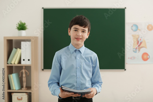 Cute boy standing in classroom