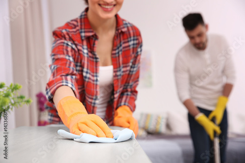 Happy young couple cleaning...