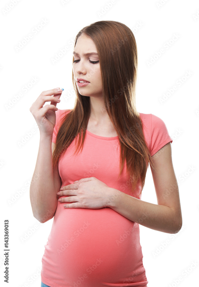 Pregnant woman taking pill against headaches on white background Pregnant woman taking pill against headaches on white background
