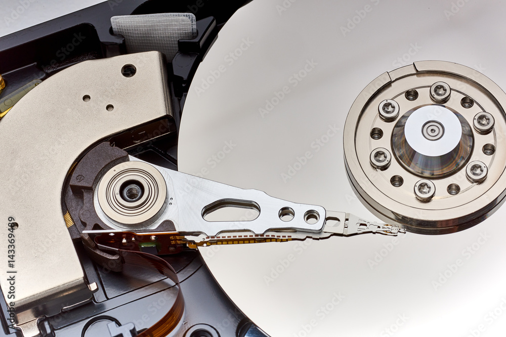 Close up inside of Hard disk drive (HDD) . Detail of writing/reading head on acuator arm and axis, spindle and platters Close up inside of Hard disk drive (HDD) . Detail of writing/reading head on acuator arm and axis, spindle and platters