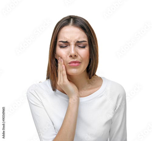 Beautiful young woman suffering from toothache on white background photo