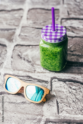 green smoothie of spinach, banana and Chia seeds. wooden sunglasses. The concept of summer and holiday