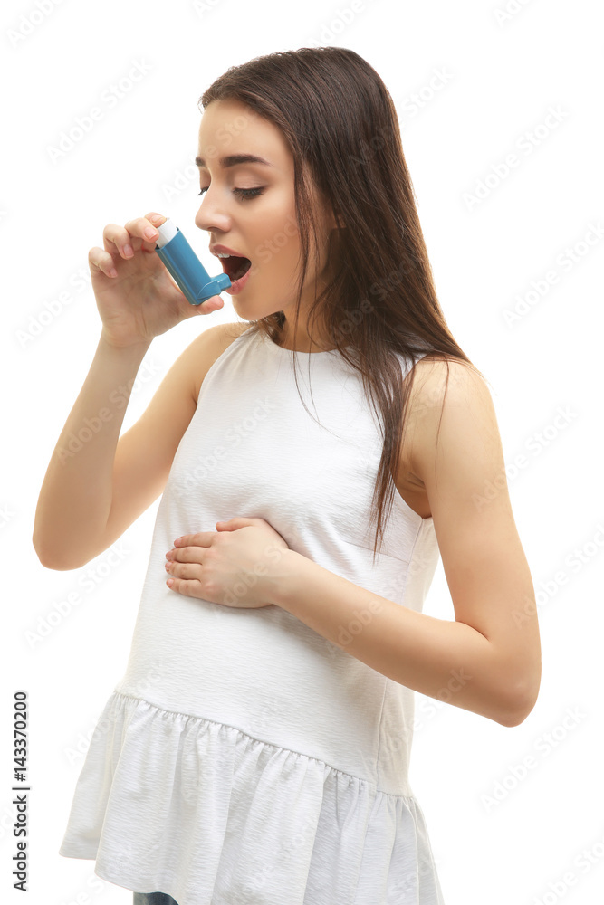 Young pregnant woman using inhaler during asthmatic attack, on white background Young pregnant woman using inhaler during asthmatic attack, on white background