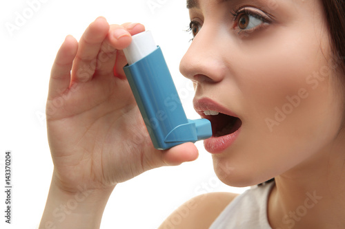 Young woman using inhaler d...