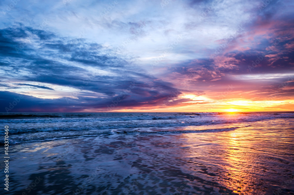 Sunset over beach with clouds