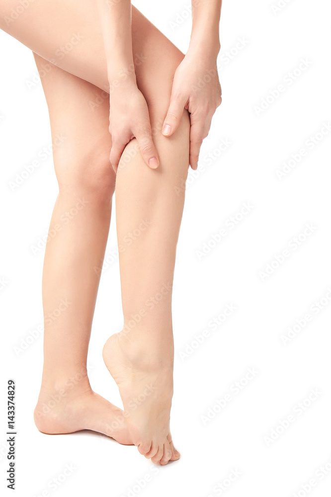 Young woman suffering from pain in leg on white background Young woman suffering from pain in leg on white background