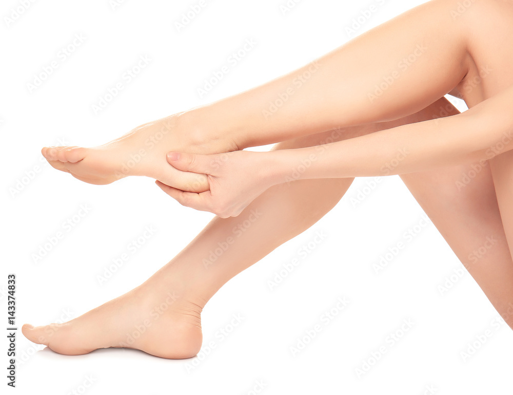 Legs of young woman suffering from pain in heel on white background Legs of young woman suffering from pain in heel on white background