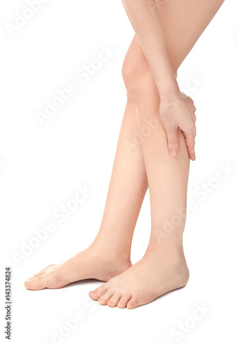 Young woman suffering from pain in legs on white background © Africa Studio
