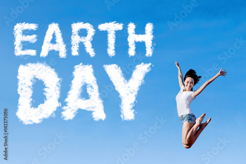 Woman leaps with Earth Day text