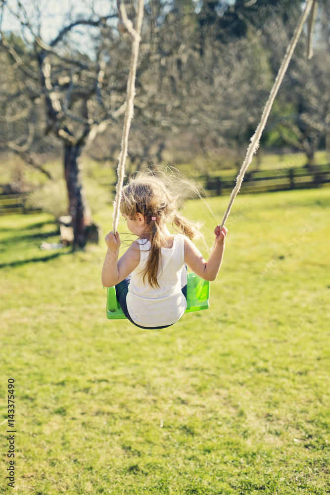 Finland, Paijat-Hame, Heinola, Rear view of girl (4-5) on swing Finland, Paijat-Hame, Heinola, Rear view of girl (4-5) on swing