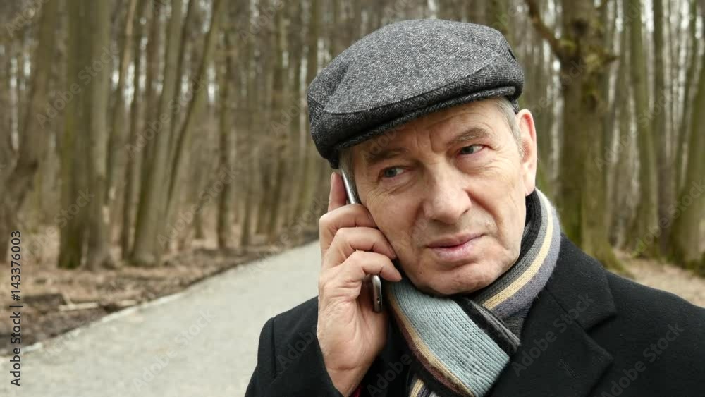Elderly Man Talking On The Phone In The Forest
