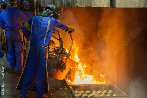 Foto perator pouring molten metal in automatic casting line in foundry factory