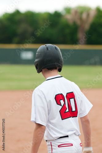 Teenage baseball boy ready to steal base.